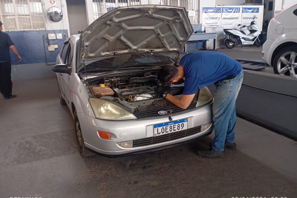 Técnico realizando inspeção visual no compartimento do motor